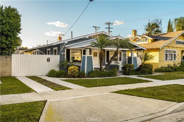 a front view of a house with a yard and potted plants