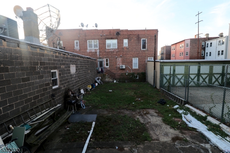 233 Adams Street Newark, NJ 07105 - Photo 4 of 14 a view of a brick house with a yard next to a road
