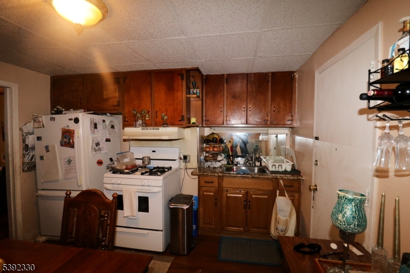 233 Adams Street Newark, NJ 07105 - Photo 8 of 14 a kitchen with refrigerator and cabinets
