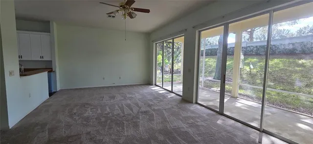 a view of a livingroom with a ceiling fan and window