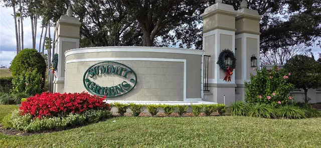 a view of a house with a small yard and large trees