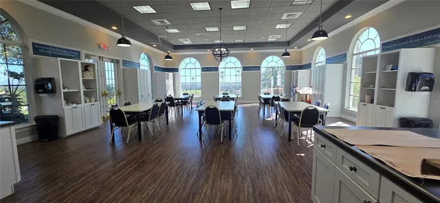 a very nice looking dining room with furniture a large window and wooden floor