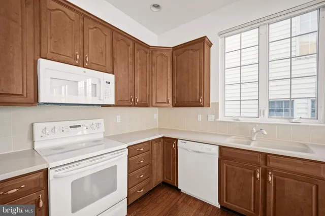 a kitchen with stainless steel appliances white cabinets sink and window