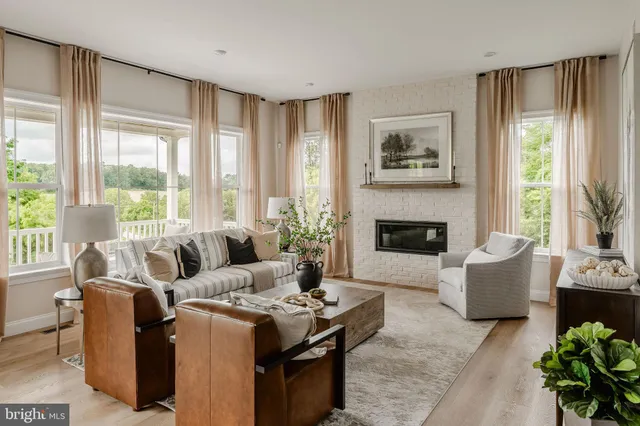 a living room with furniture large window and a fireplace