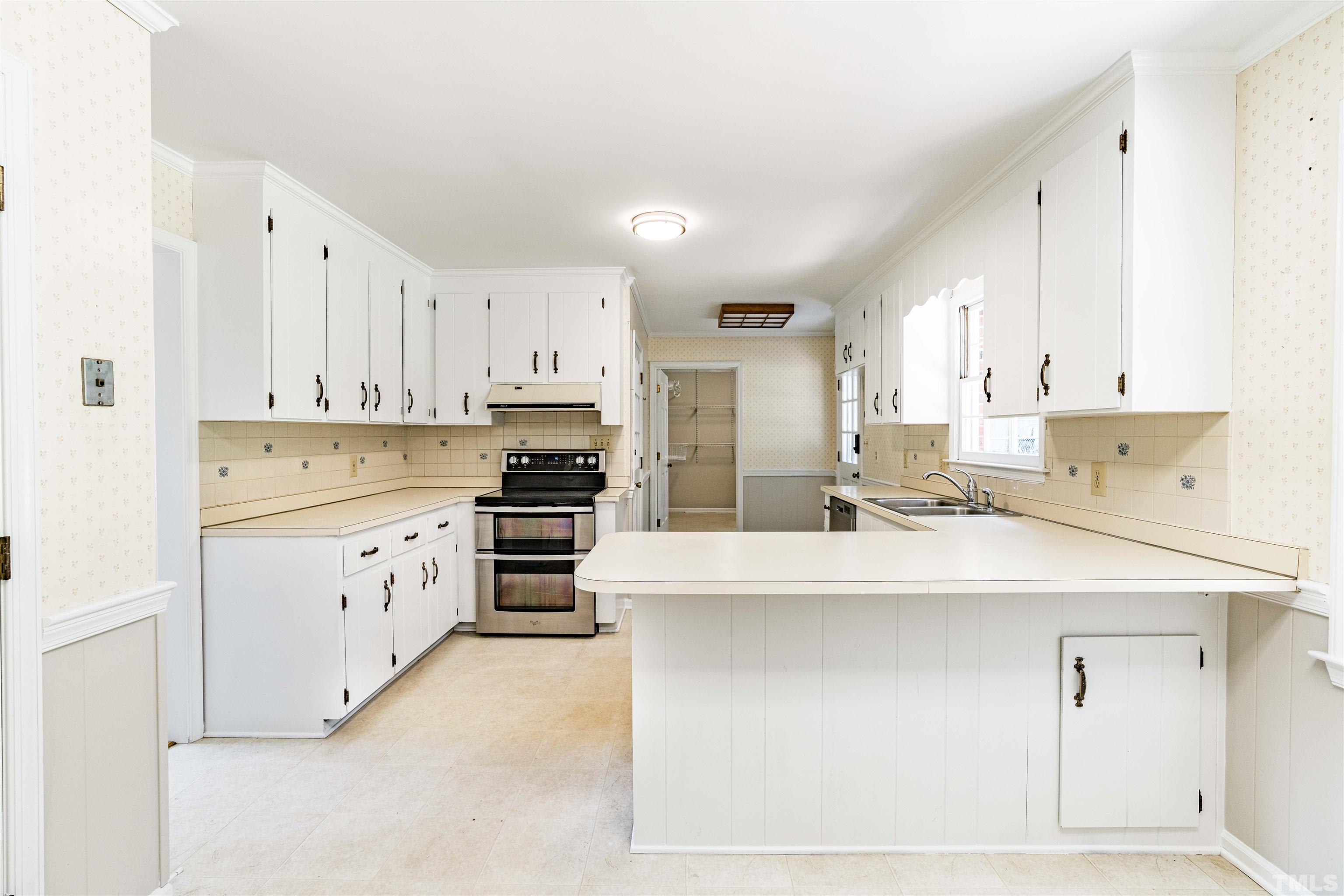 8645 Valley Brook Drive Raleigh, NC 27613 - Photo 11 of 32 a kitchen with stainless steel appliances kitchen island sink stove and cabinets