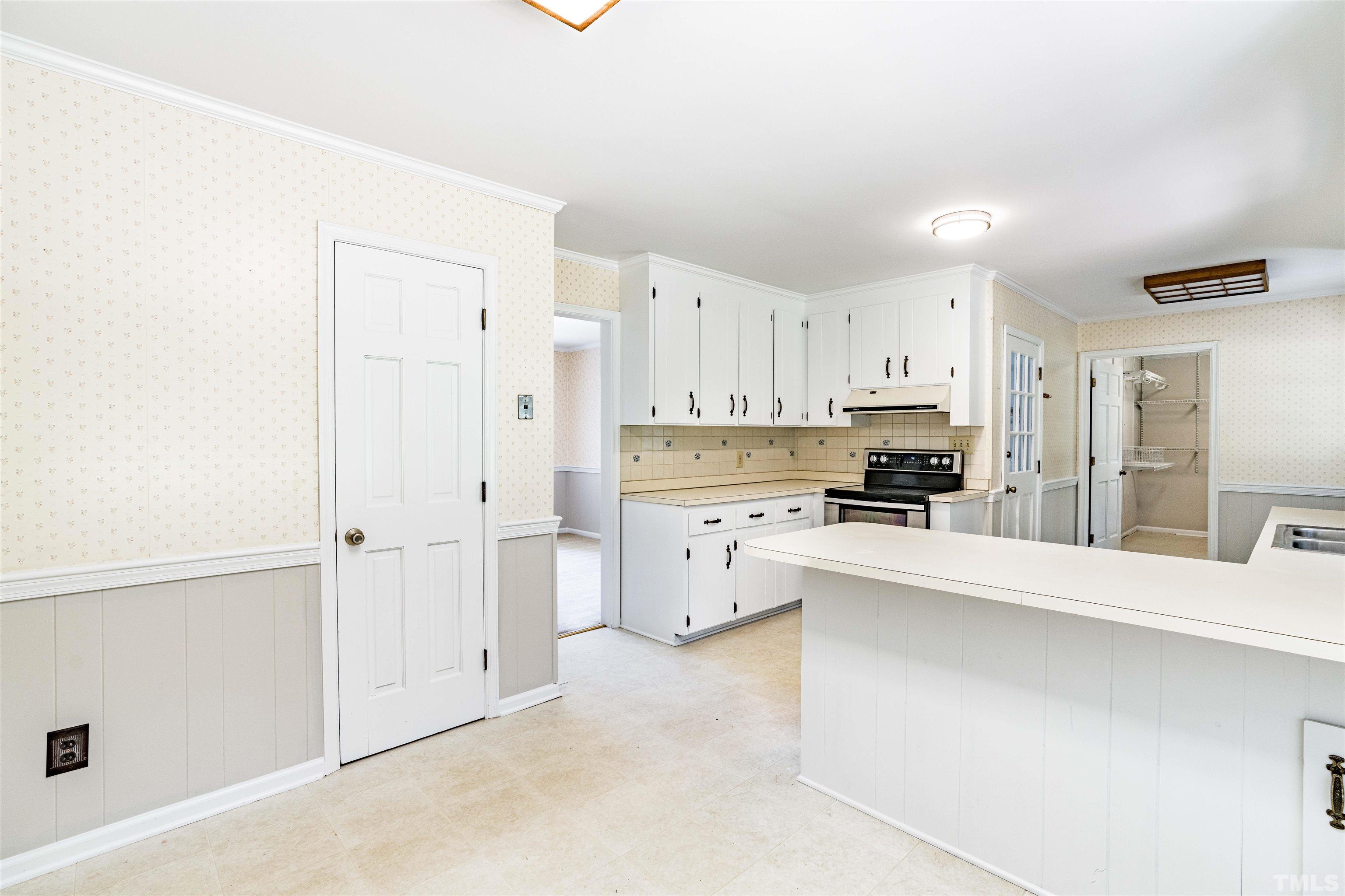 8645 Valley Brook Drive Raleigh, NC 27613 - Photo 12 of 32 a kitchen with white cabinets and white appliances
