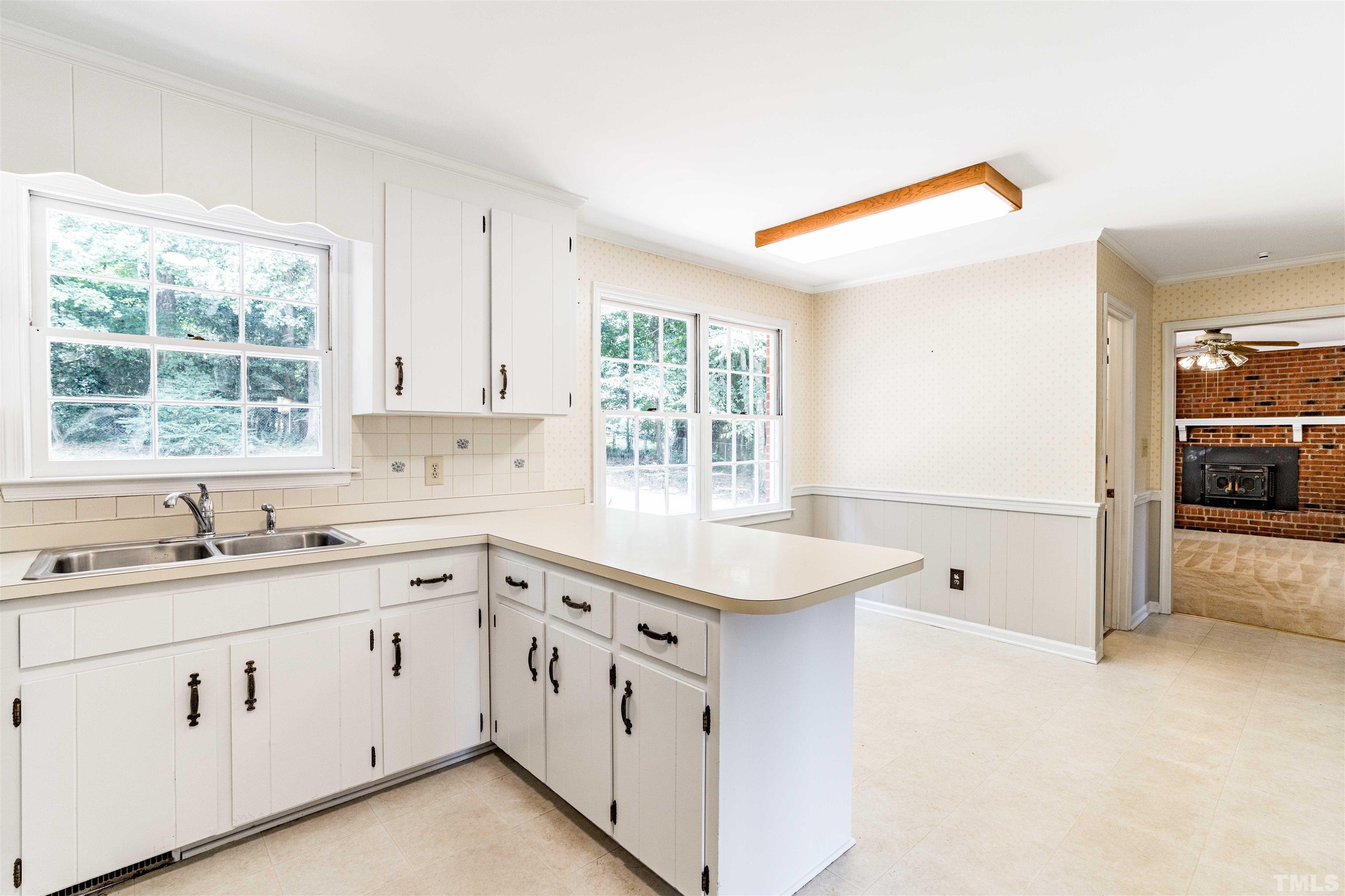 8645 Valley Brook Drive Raleigh, NC 27613 - Photo 13 of 32 a kitchen with white cabinets and a sink