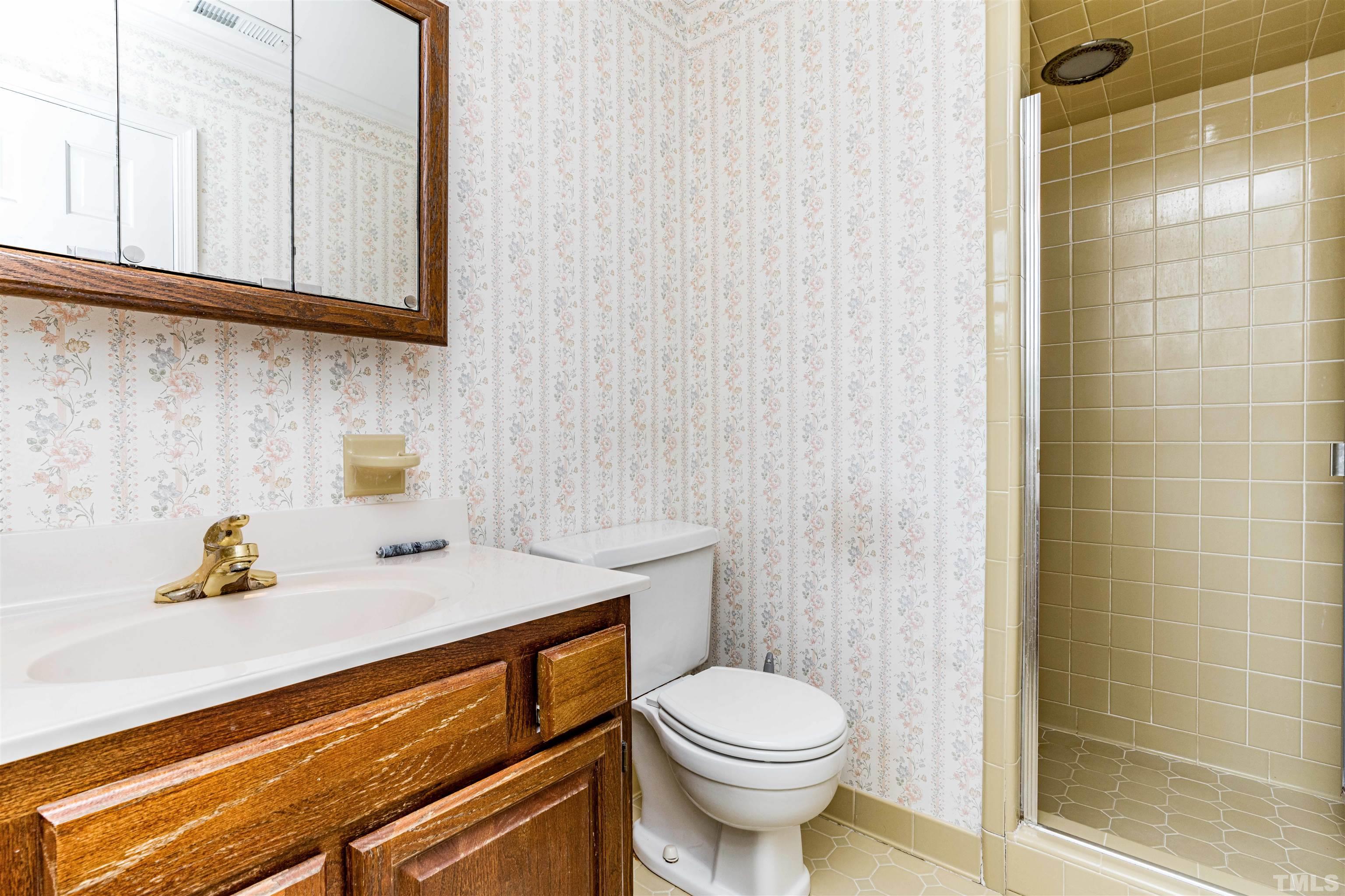 8645 Valley Brook Drive Raleigh, NC 27613 - Photo 20 of 32 a bathroom with a sink a toilet and shower