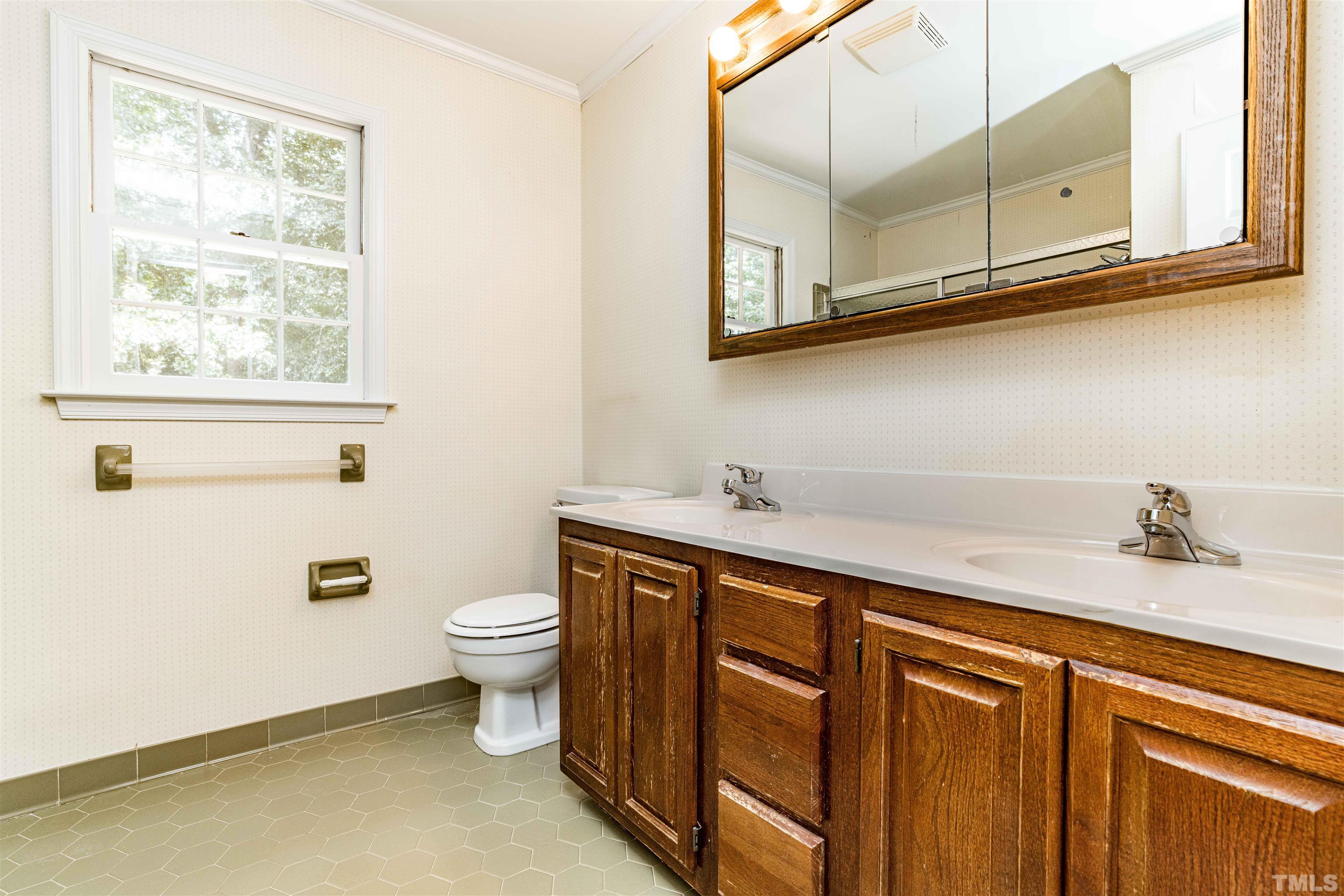 8645 Valley Brook Drive Raleigh, NC 27613 - Photo 29 of 32 a bathroom with a granite countertop sink a large mirror and a toilet