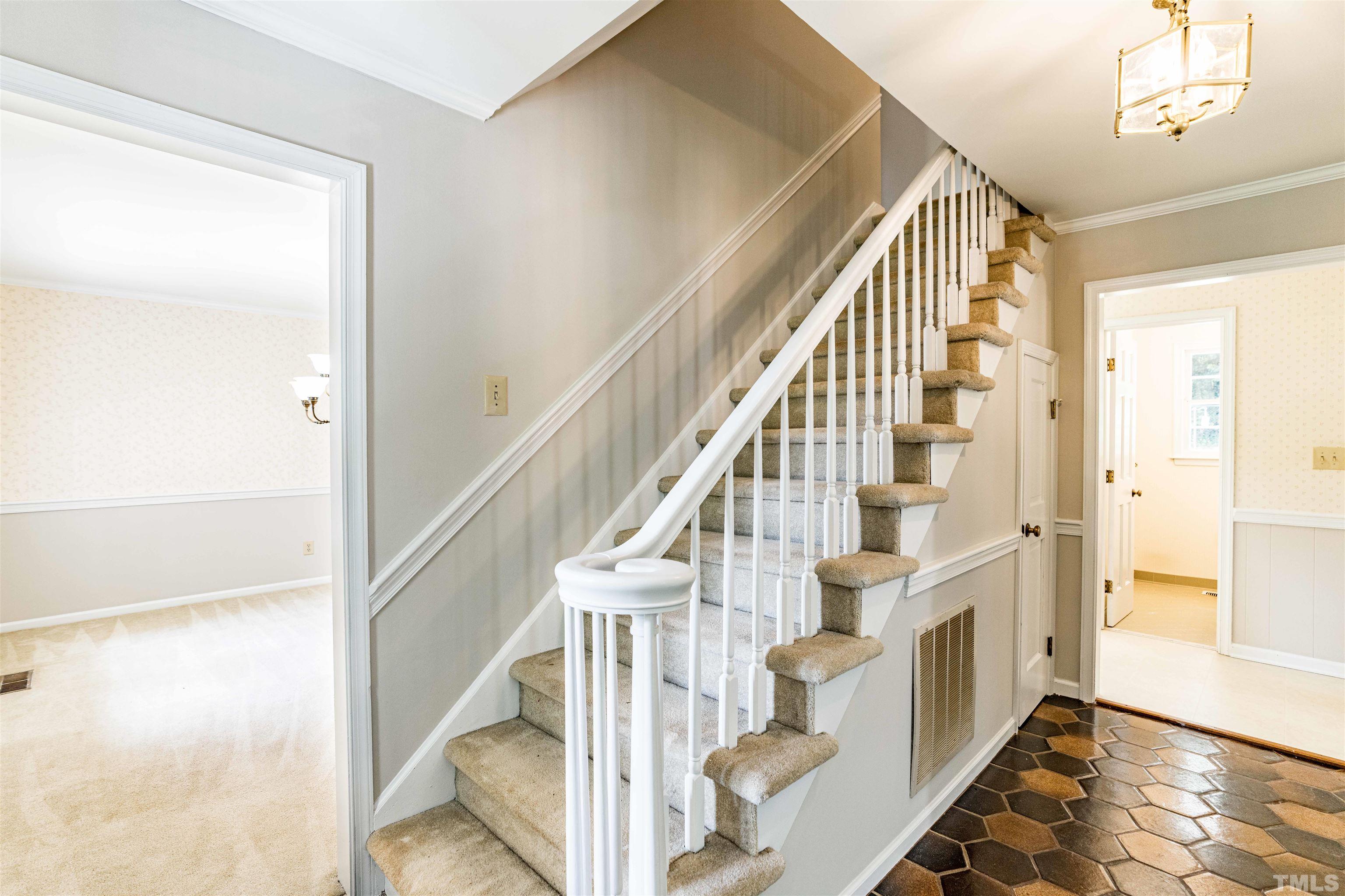 8645 Valley Brook Drive Raleigh, NC 27613 - Photo 4 of 32 a view of staircase with wooden floor and staircase