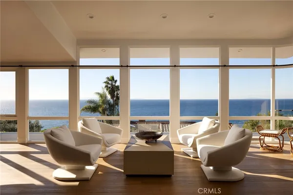 a living room with furniture and floor to ceiling windows