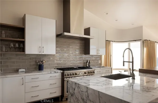 a kitchen with granite countertop a sink a stove and cabinets