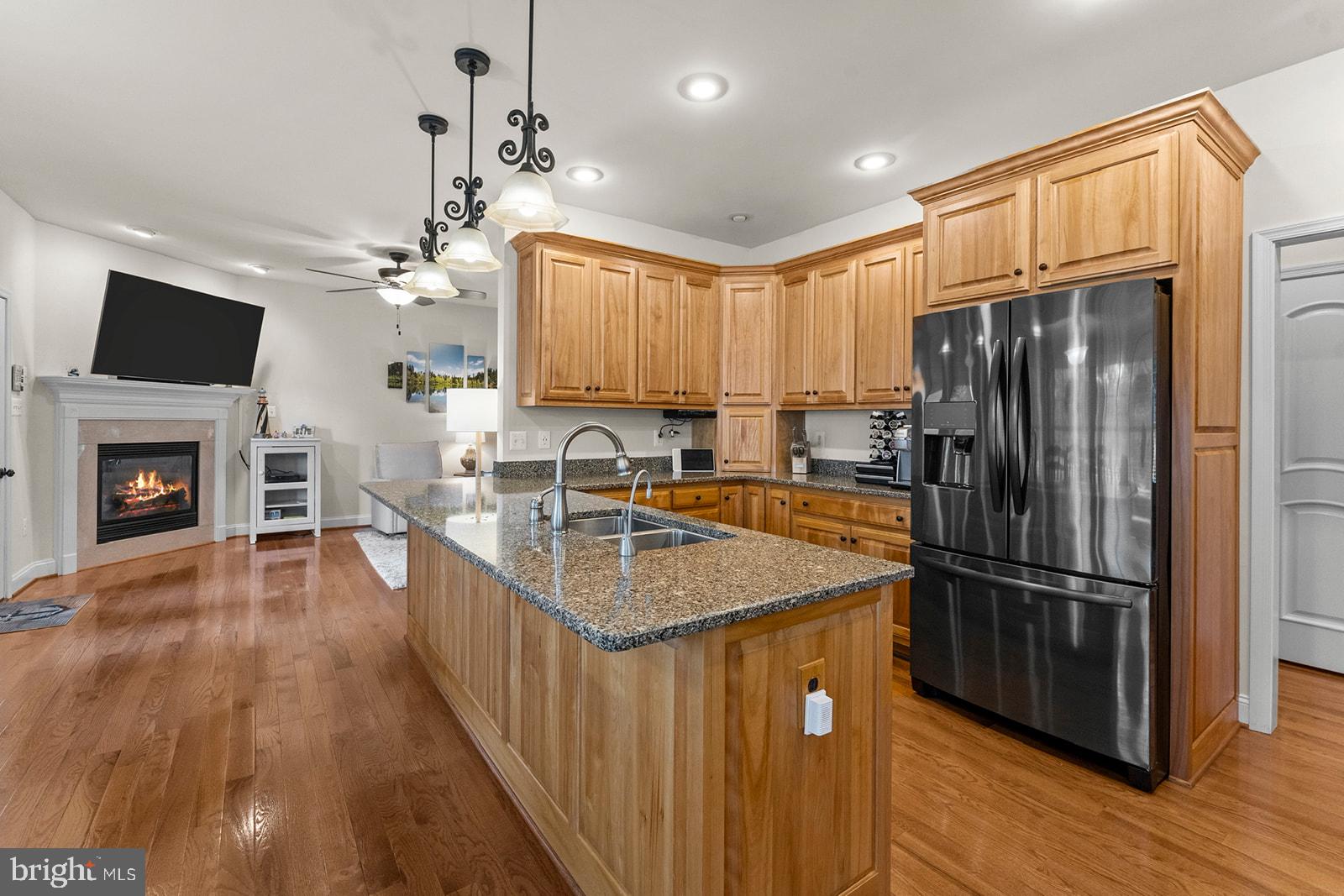 32 Dobe Point Road Stafford, VA 22554 - Photo 6 of 38 a kitchen with stainless steel appliances granite countertop a refrigerator a sink dishwasher a stove and a dining table with wooden floor