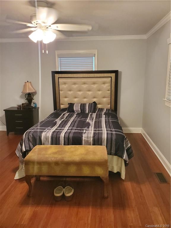 4501 Farmbrook Road Gastonia, NC 28056 - Photo 21 of 23 a bedroom with a bed and a chandelier