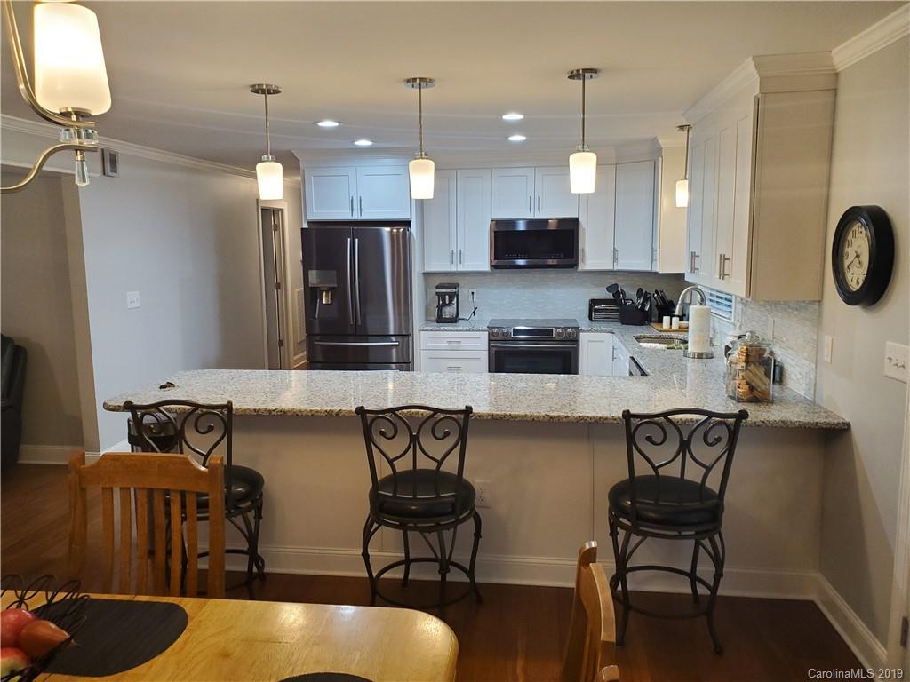 4501 Farmbrook Road Gastonia, NC 28056 - Photo 5 of 23 a kitchen with stainless steel appliances kitchen island granite countertop a dining table chairs and a refrigerator