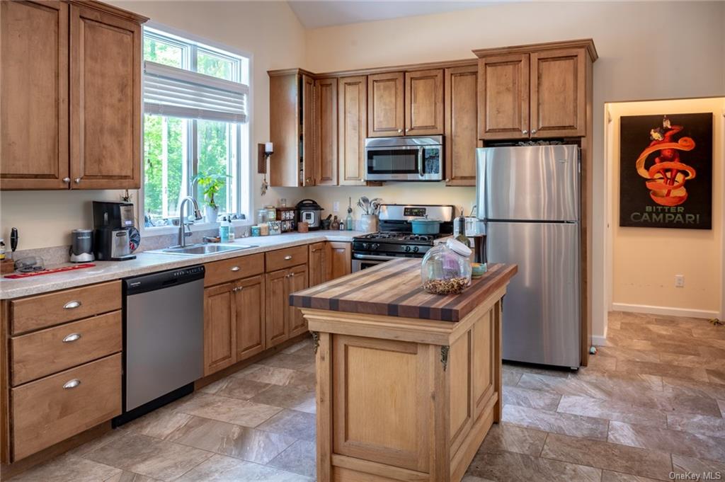 15 Sickletown Road Pearl River, NY 10965 - Photo 31 of 35 a kitchen with stainless steel appliances granite countertop a refrigerator a sink a stove a microwave and wooden cabinets