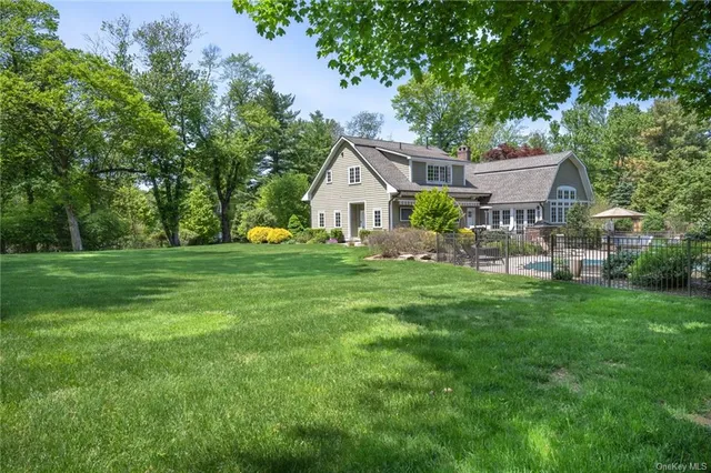 a front view of a house with a yard and trees