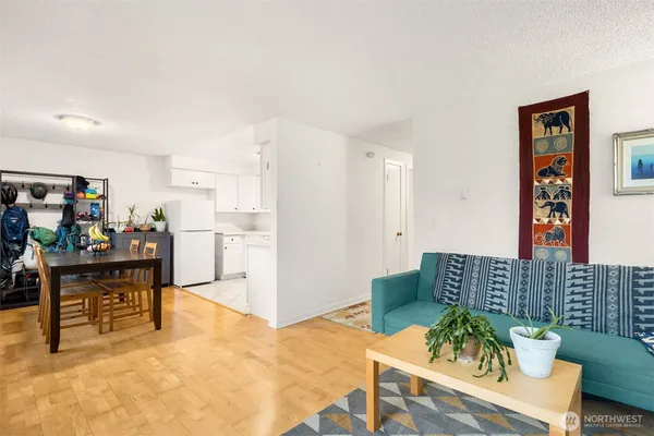 a living room with furniture and a dining table with wooden floor