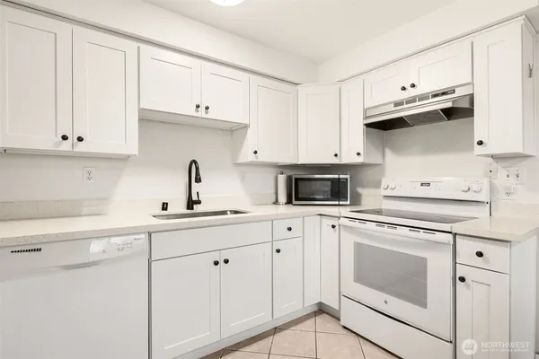 a kitchen with cabinets stainless steel appliances and a sink