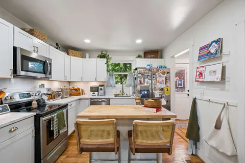 a kitchen with granite countertop white cabinets and white appliances