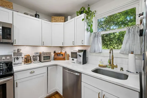 a kitchen with stainless steel appliances kitchen island granite countertop a refrigerator and a stove top oven