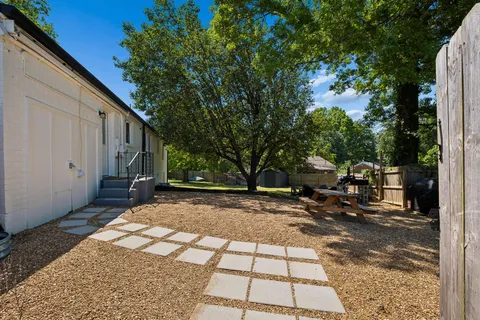 a backyard of a house with barbeque oven fire pit table and chairs