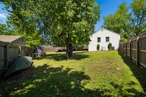 a backyard of a house with yard table and chairs