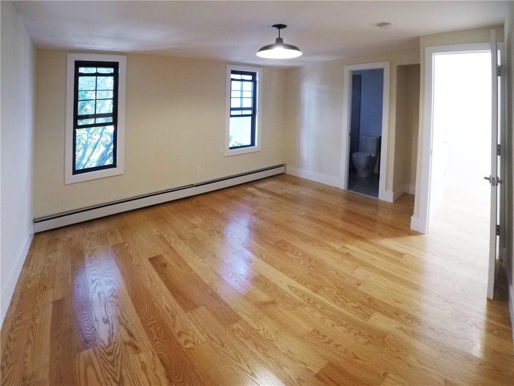 38 Troy Avenue Brooklyn, NY 11213 - Photo 12 of 16 an empty room with wooden floor and windows