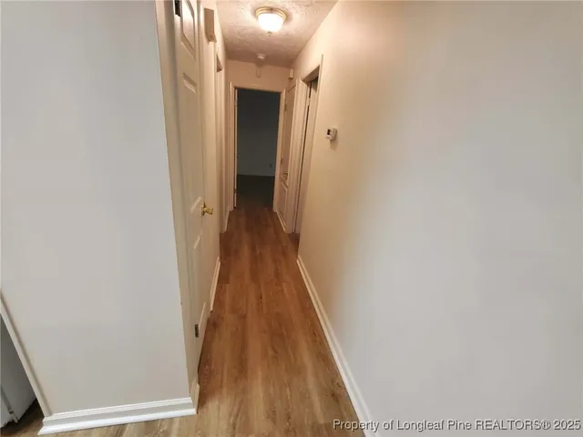 a view of a hallway with wooden floor and a hallway