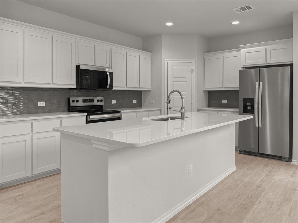 1908 Iris Road Melissa, TX 75454 - Photo 6 of 30 a kitchen with stainless steel appliances granite countertop a sink a stove a refrigerator and cabinets