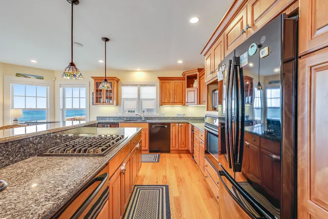 a kitchen with stainless steel appliances granite countertop sink stove and refrigerator