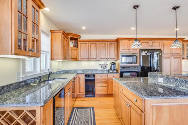 a kitchen with stainless steel appliances granite countertop a sink a stove top oven a counter space and cabinets