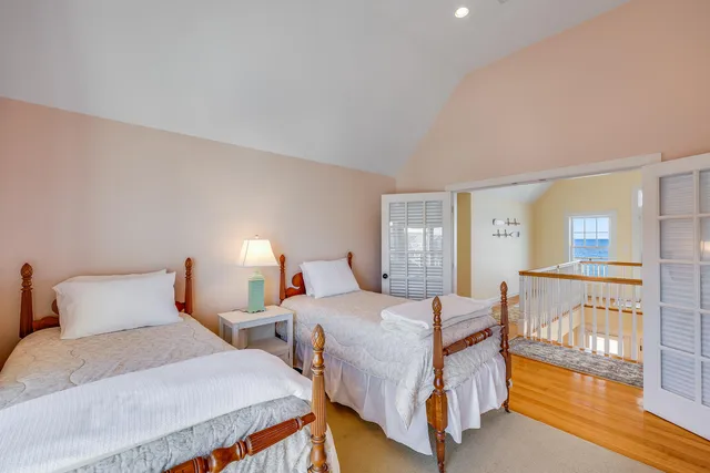 a bedroom with two beds and wooden floor