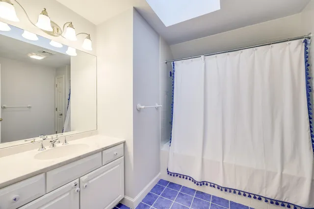 a bathroom with a sink a mirror and a shower curtain