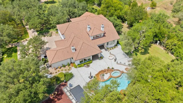 an aerial view of a house with a swimming pool and garden