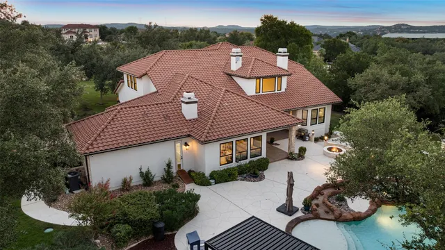 a aerial view of a house with a yard and balcony