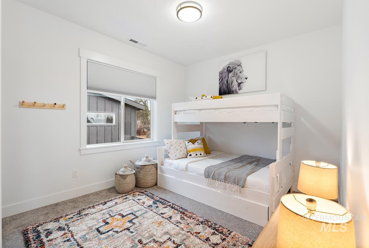599 West Warren Street Boise, ID 83706 - Photo 37 of 41 Bright interior room featuring a window with a roller shade, light-colored walls, and carpet flooring