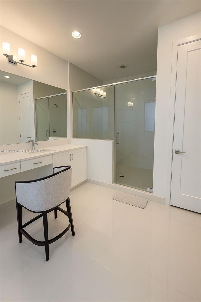 8185 Crystal Downs Avenue Boca Raton, FL 33434 - Photo 17 of 27 a bathroom with a sink mirror and a shower