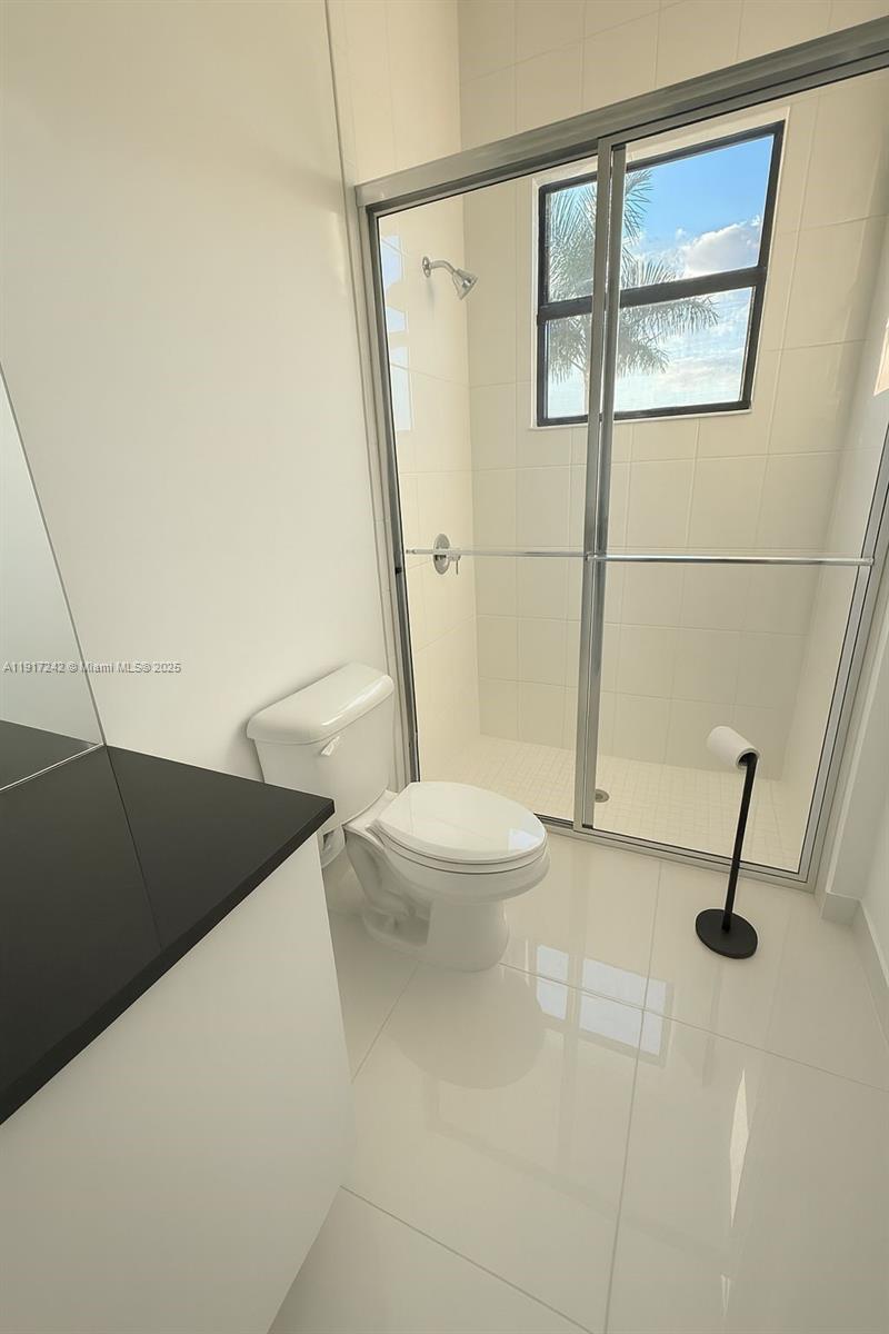 8185 Crystal Downs Avenue Boca Raton, FL 33434 - Photo 20 of 27 a bathroom with a granite countertop sink toilet and shower