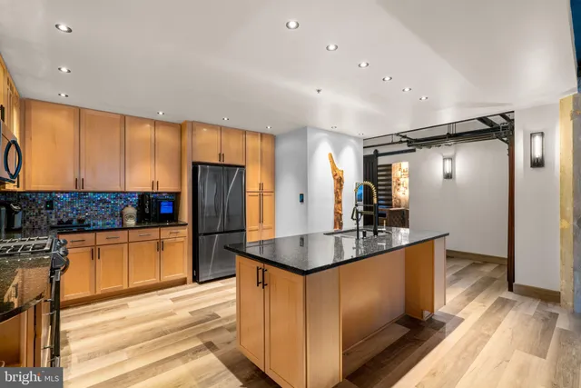 a kitchen with stainless steel appliances granite countertop a refrigerator and a sink