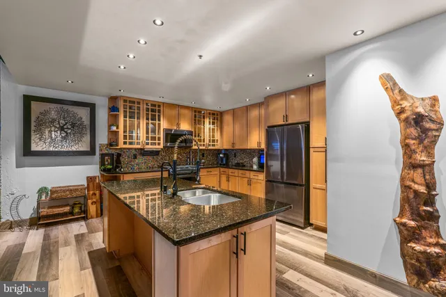 a kitchen with stainless steel appliances granite countertop a sink refrigerator and cabinets