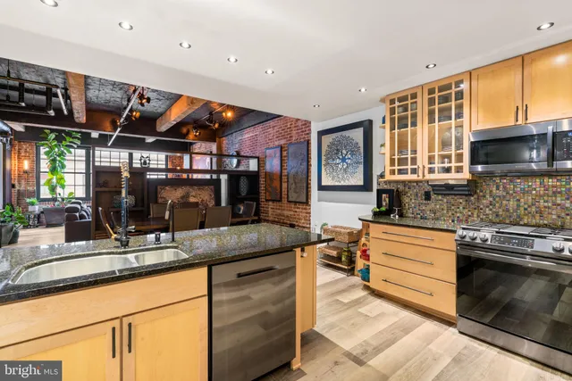a kitchen with stainless steel appliances granite countertop a sink and cabinets