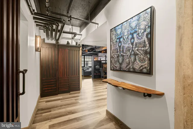 a view of a hallway with wooden floor and windows