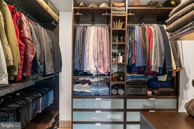 a view of walk in closet with clothes and shoes
