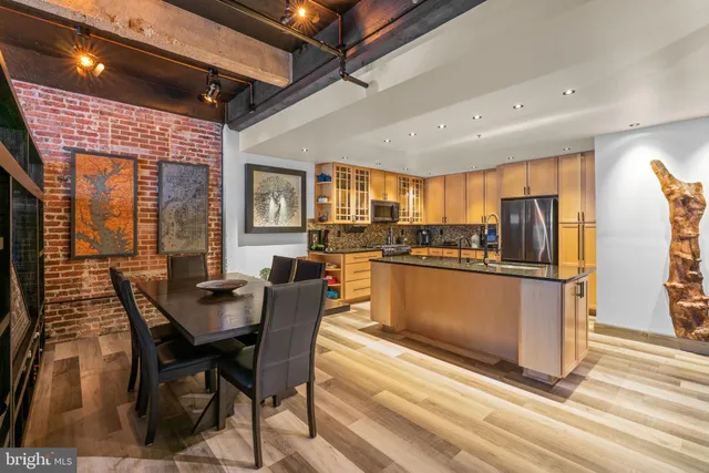 a kitchen with stainless steel appliances kitchen island granite countertop a refrigerator and microwave