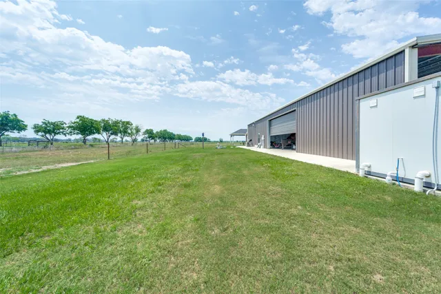 a backyard of a house with lots of green space and lake view