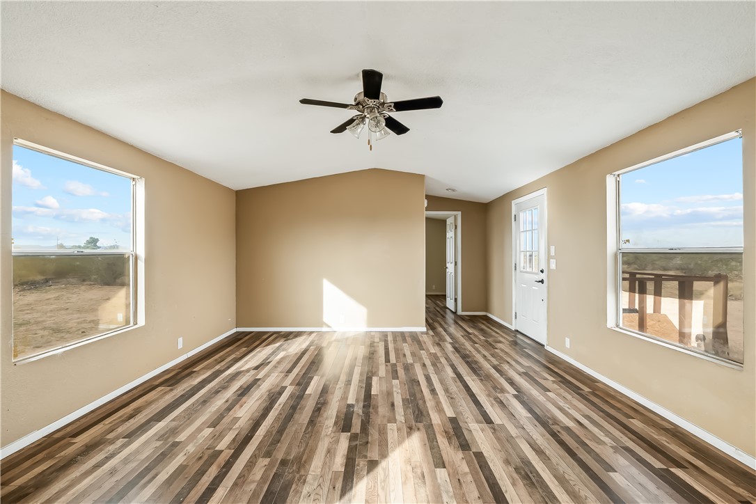 3649 Araby Road Golden Valley, AZ 86413 - Photo 12 of 29 Spacious room featuring wood-finish flooring, a vaulted ceiling, and a ceiling fan with light fixture