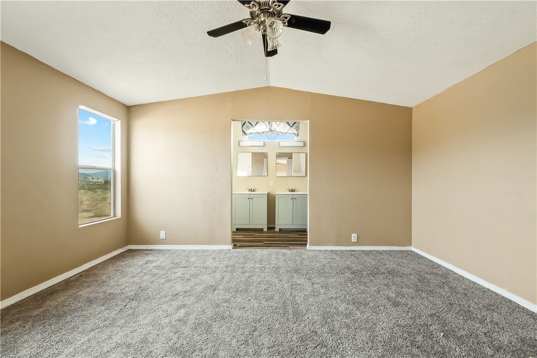 3649 Araby Road Golden Valley, AZ 86413 - Photo 20 of 29 Vaulted ceiling with a ceiling fan, grey carpeting, and a window with a landscape backdrop