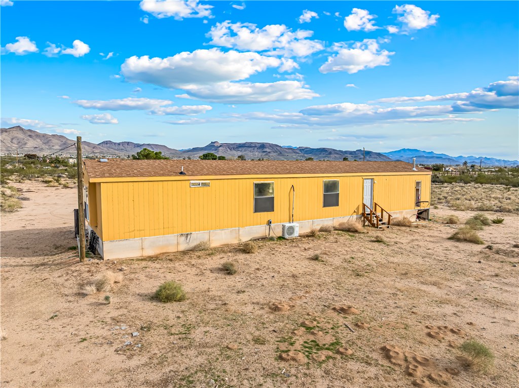 3649 Araby Road Golden Valley, AZ 86413 - Photo 27 of 29 Single-story dwelling featuring a yellow exterior, brown shingle roof, and multiple windows