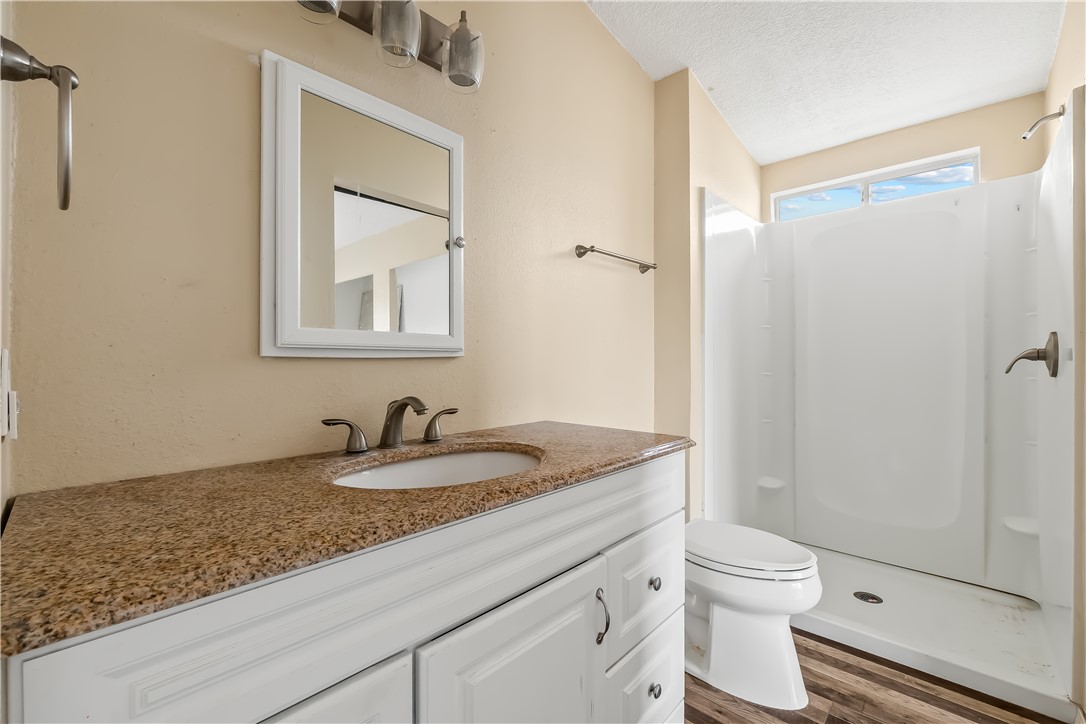3649 Araby Road Golden Valley, AZ 86413 - Photo 7 of 29 Bathroom featuring a white vanity with a granite countertop, undermount sink, and brushed nickel faucet